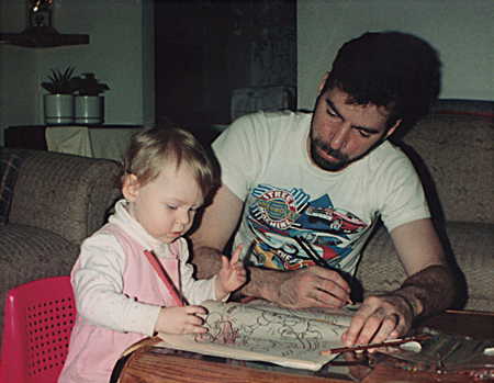 Photograph of one and a half year old Danielle MacDonald colouring with her dad, using pencil crayons in a Disney colouring book.